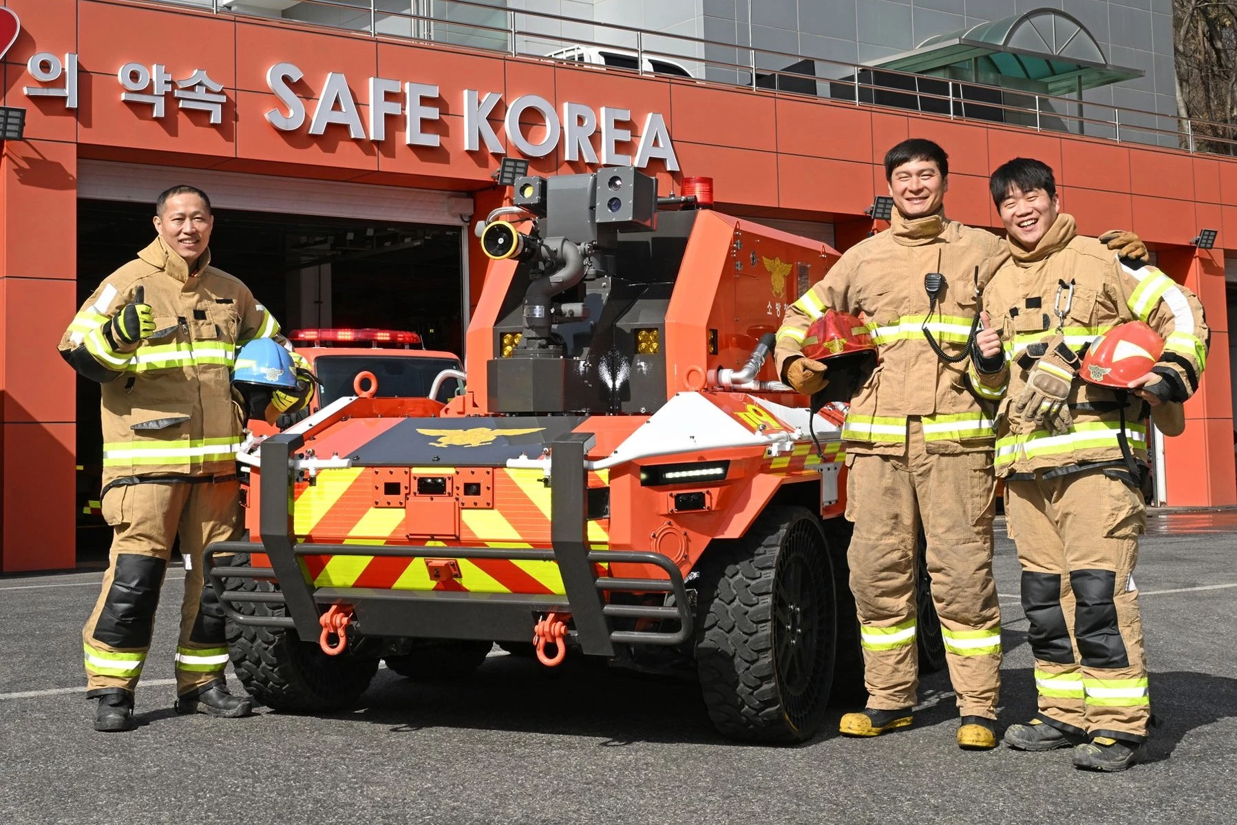 A group of firefighters gathers around the new robotic helper