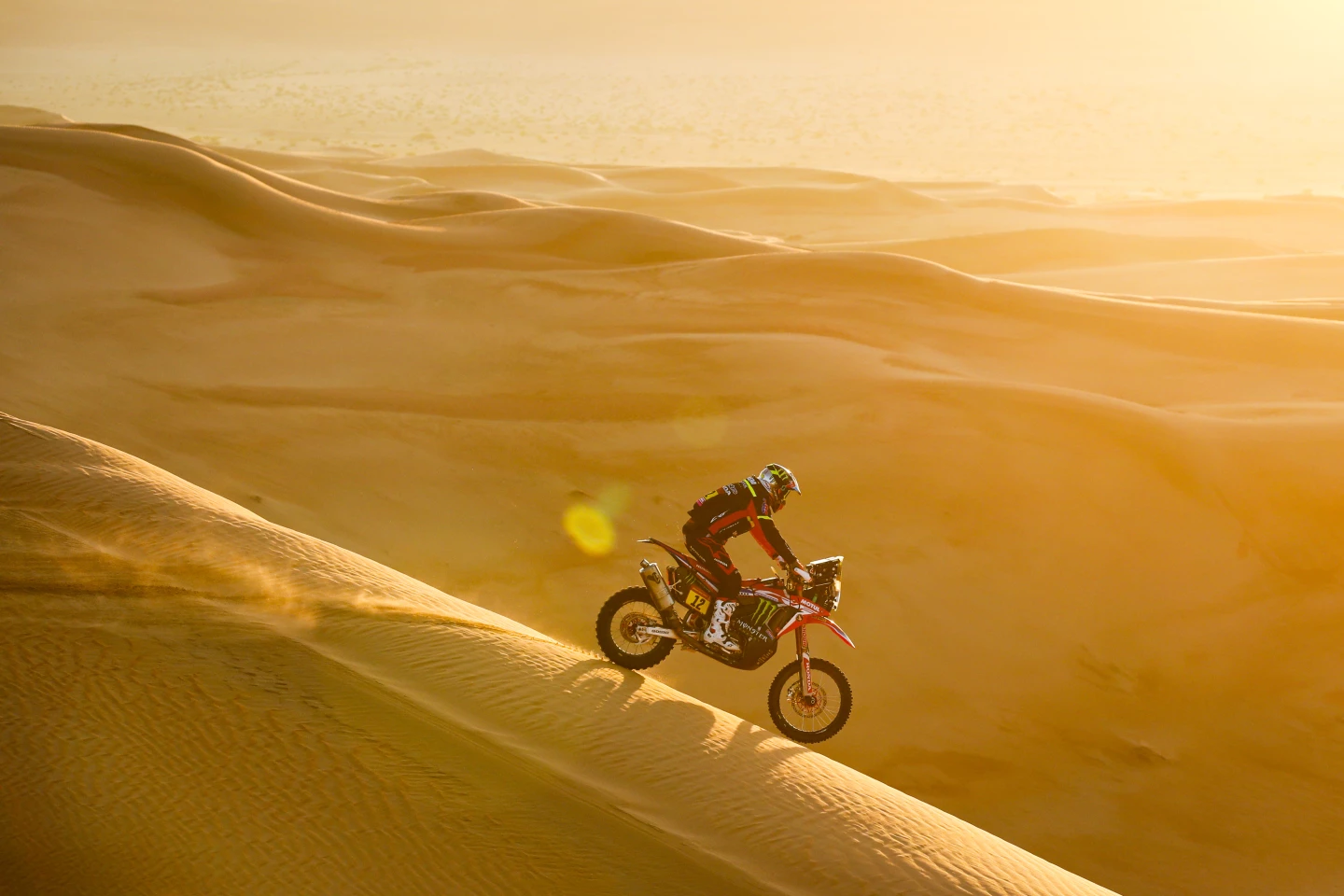 Endless, glowing sands extend into the distance behind Joan Barreda Bort on his Honda