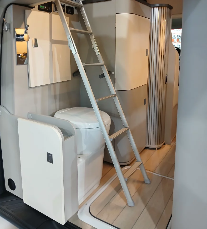 The open rear bathroom with inbuilt cassette toilet, shower pan with floor-matching cover and foldaway ladder to the upstairs bed can be made semi-private with the closed tailgate, tailgate window shade and roll-out interior privacy curtain