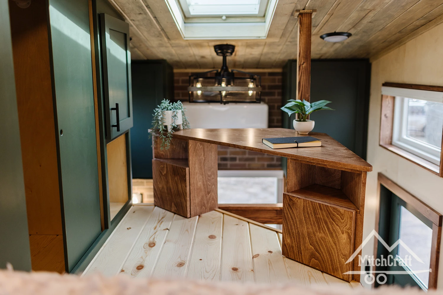 Nicole's 16 × 8 Tiny Home includes a home office area, which is positioned so that the owner's legs can dangle off the side, making it a little more comfortable than having to sit cross-legged