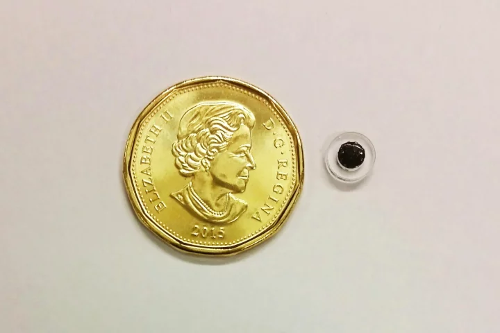 A prototype "microspouter" with a Canadian dollar coin for scale