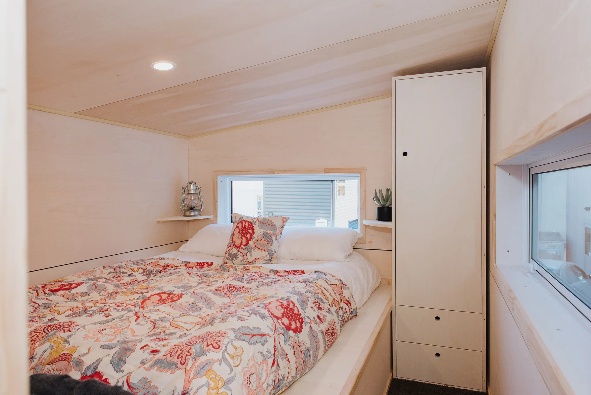 The Purple Palace has one bedroom, which is a typical tiny house-style bedroom and contains a double bed and some storage space. A lowered standing platform next to the bed makes getting dressed easier in the compact space