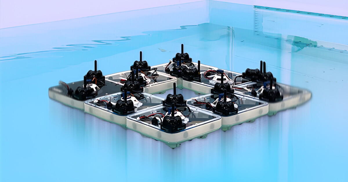 Small square robotic tiles floating on water, connected edge-to-edge by magnetic latches to form a larger rectangular platform.
