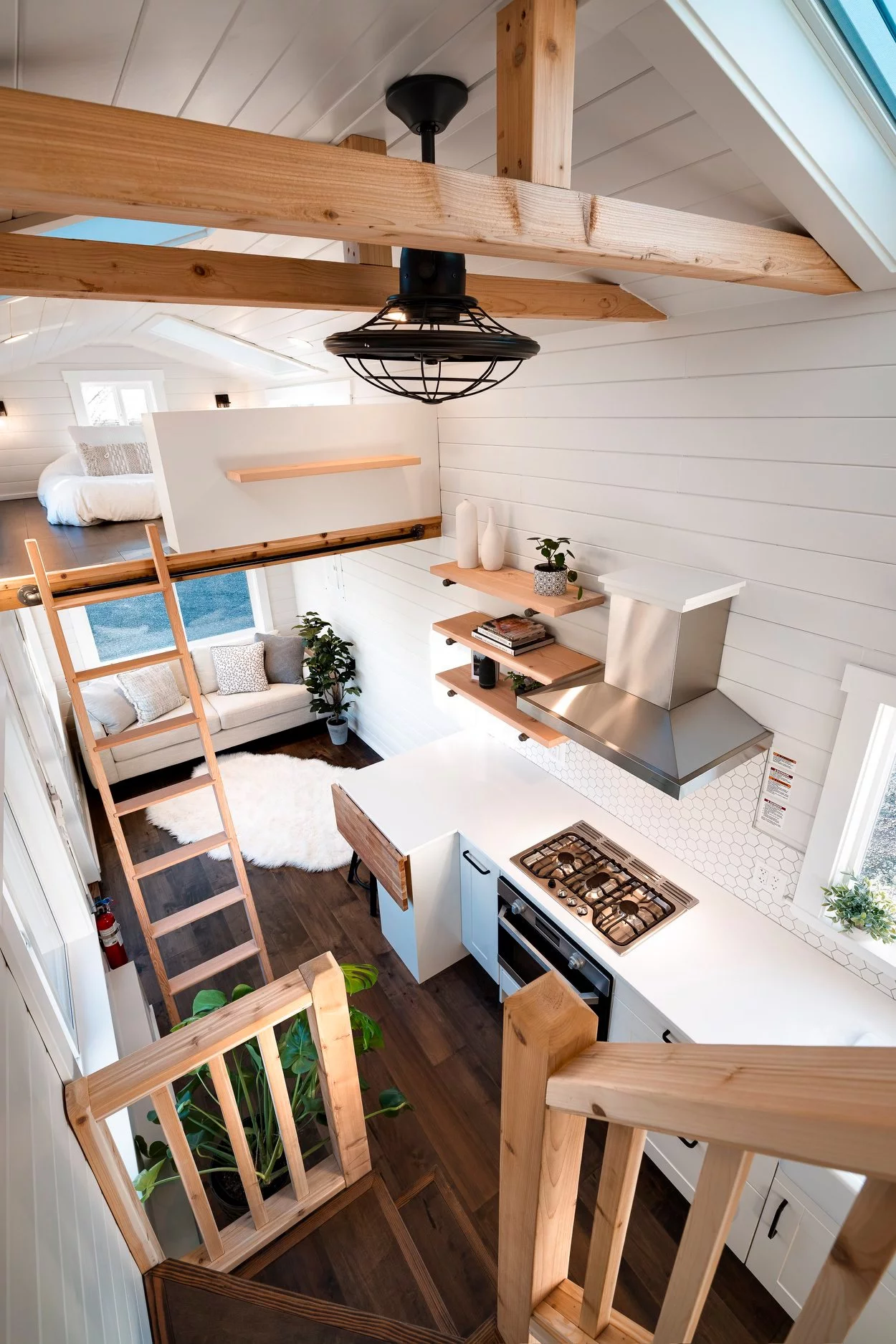 The 34ft Eco-Friendly Tiny House RV's kitchen has quite a bit of storage in the shape of cabinetry and shelving