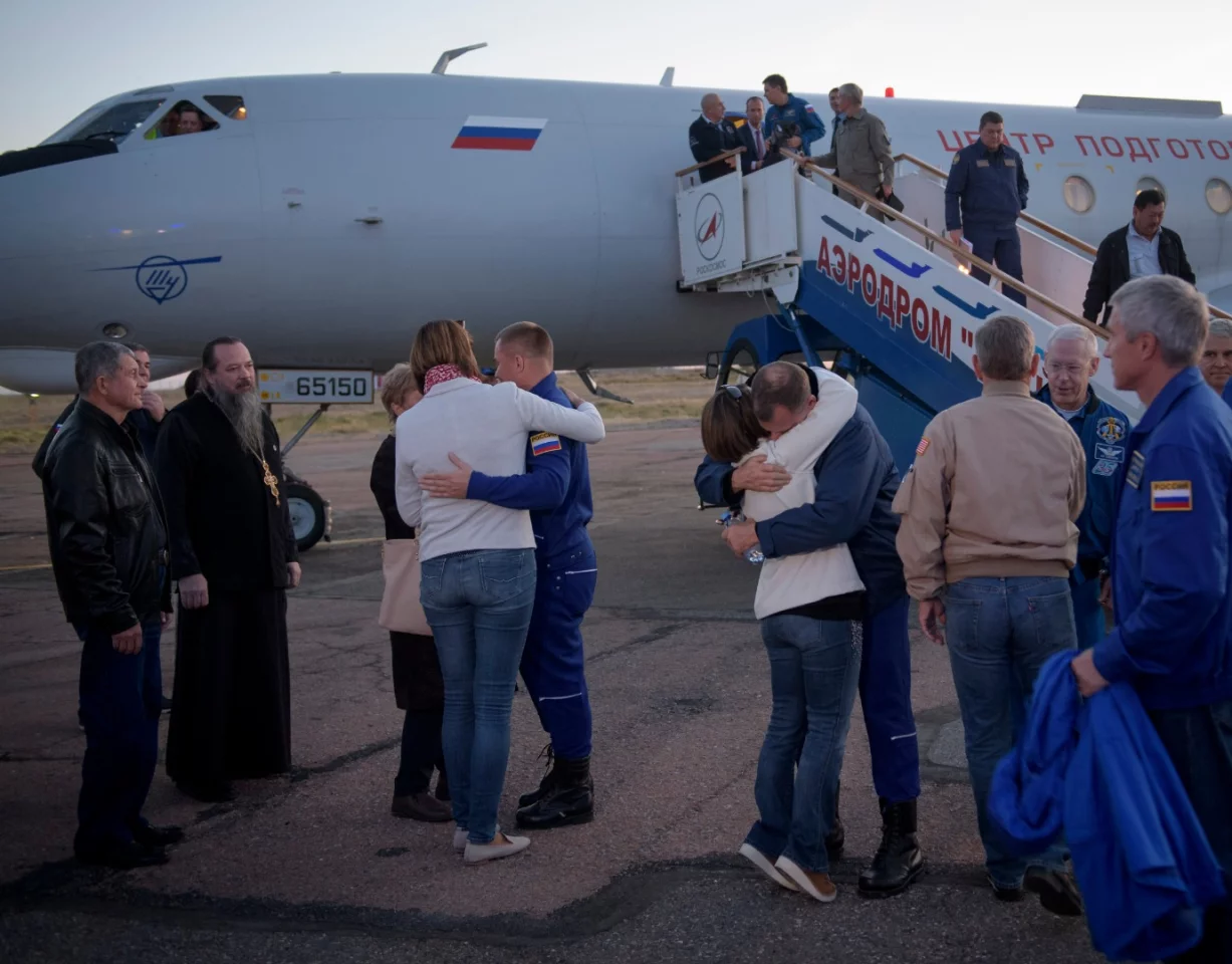 Expedition 57 Flight Engineer Alexey Ovchinin of Roscosmos, left, and Flight Engineer Nick Hague of NASA, right. embrace their families after landing at the Krayniy Airport,