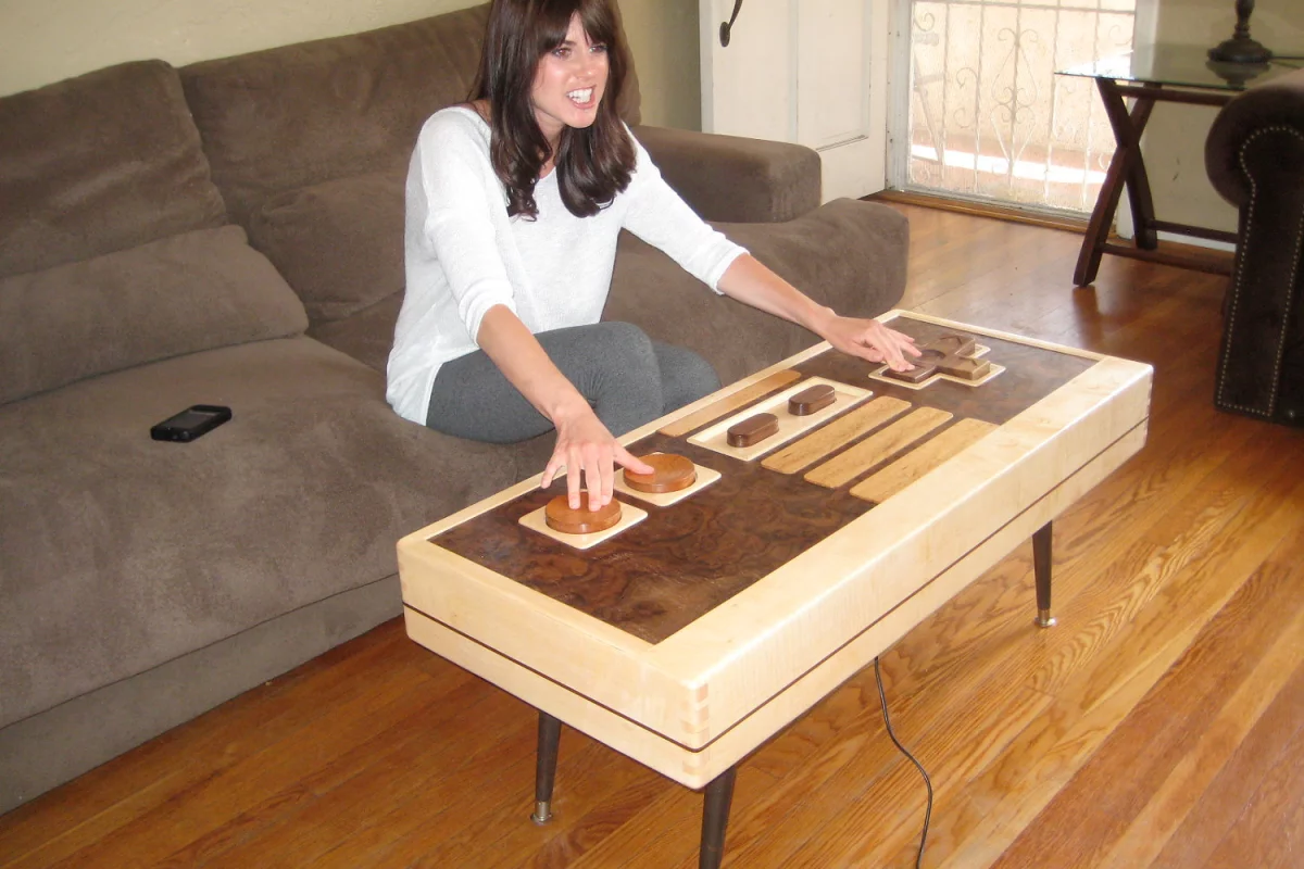 Charles Lushear has designed and built a coffee table that resembles a Nintendo Entertainment System controller, with buttons and a joypad that can actually control onscreen gaming action