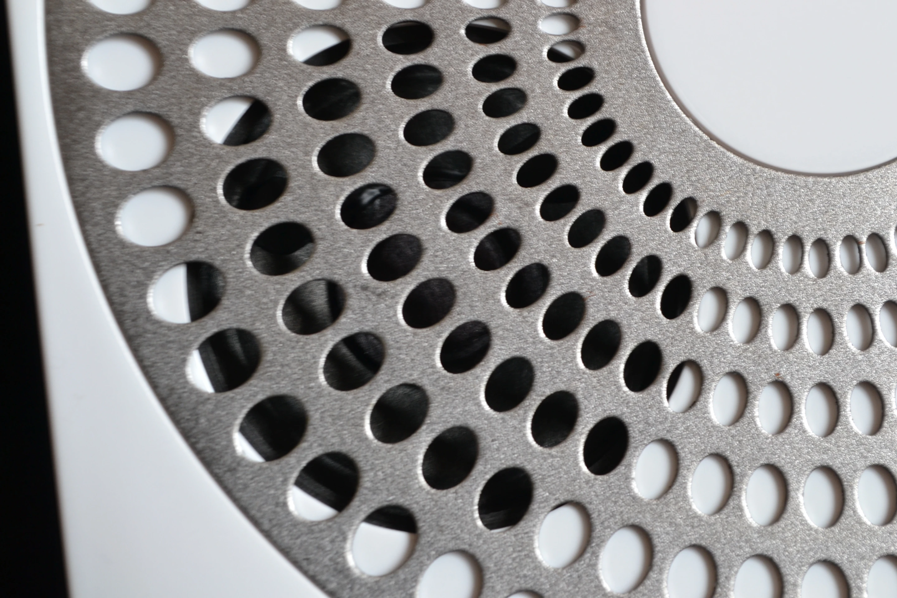 Close up of one of Ubi's speakers behind the metal grille