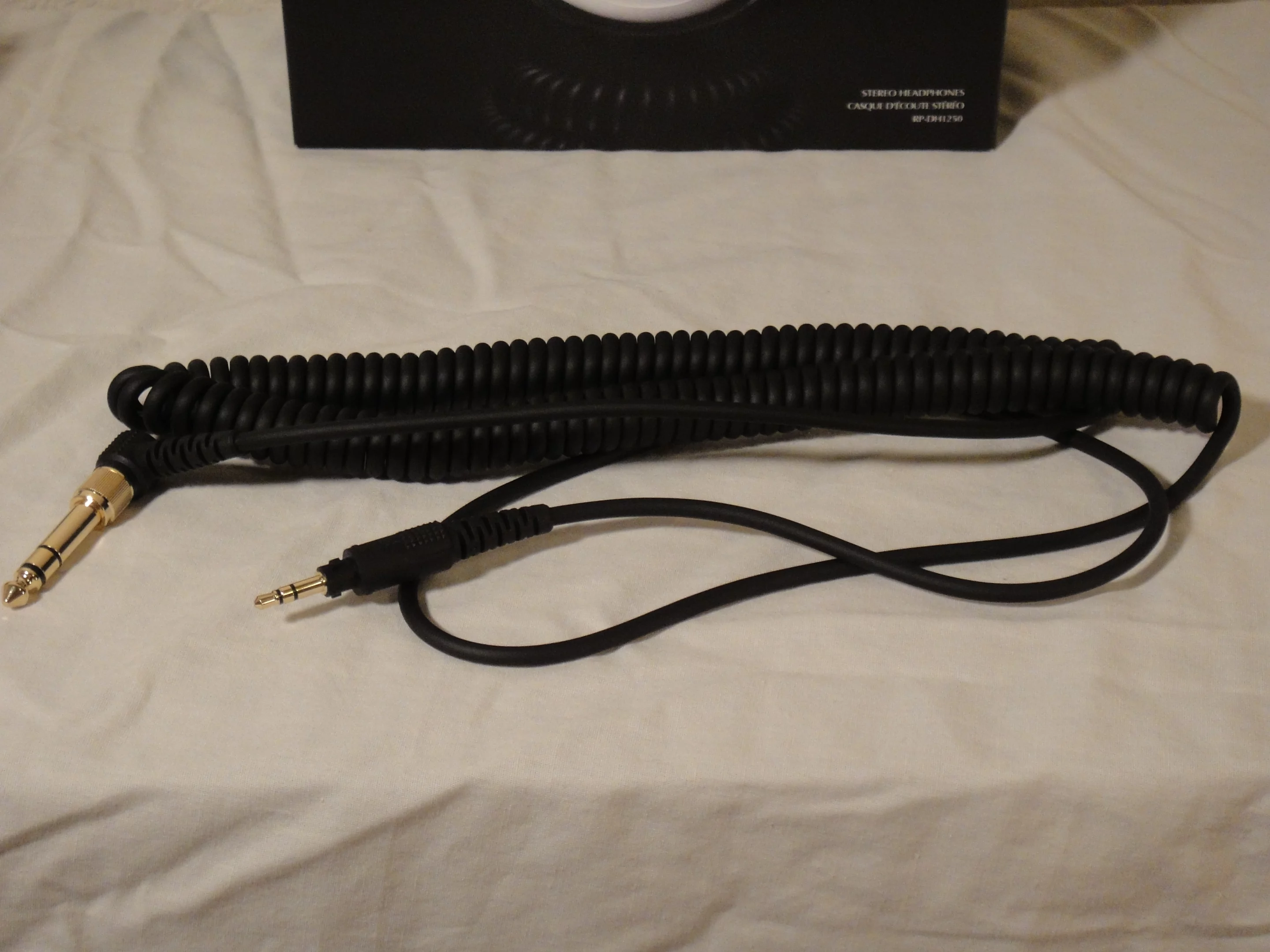 Both cords are the same length (1.2m/3.9ft), but the coiled one stretches to almost three times that (3m/9.8ft)