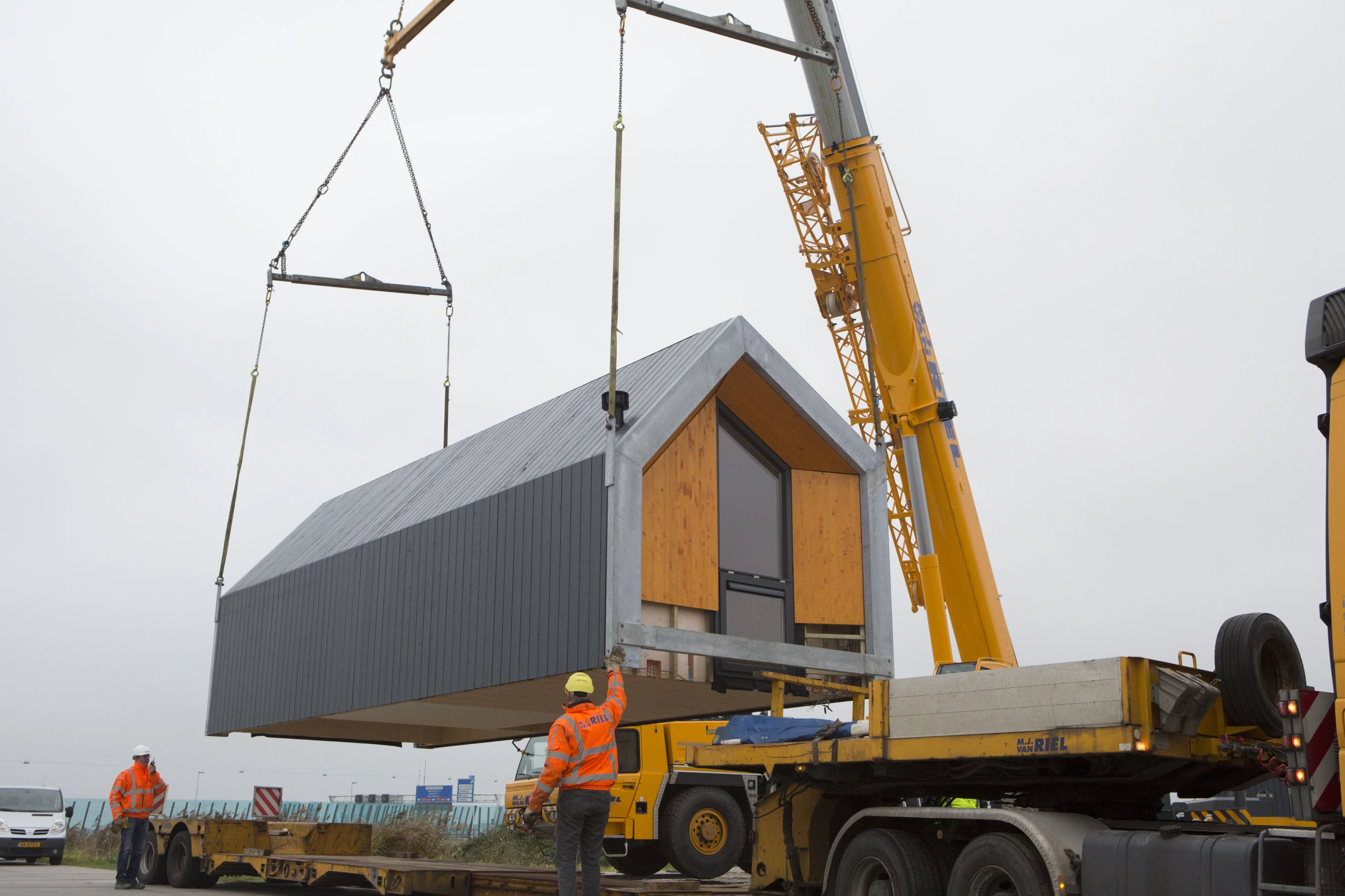 The Heijmans ONE is transported by truck and placed into position by crane