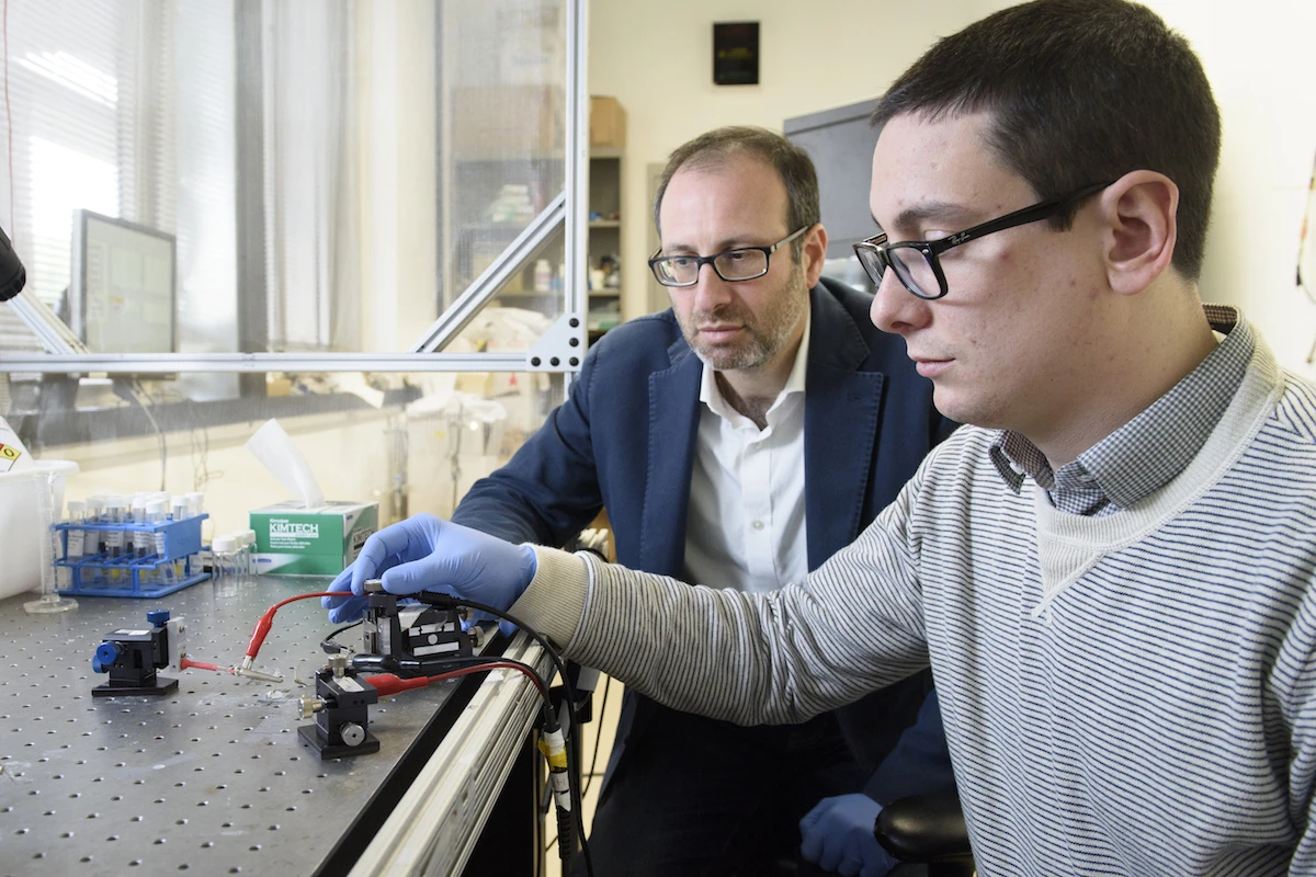 Alberto Salleo (left) and Scott Keene, two of the researchers on the project, test the artificial synapse