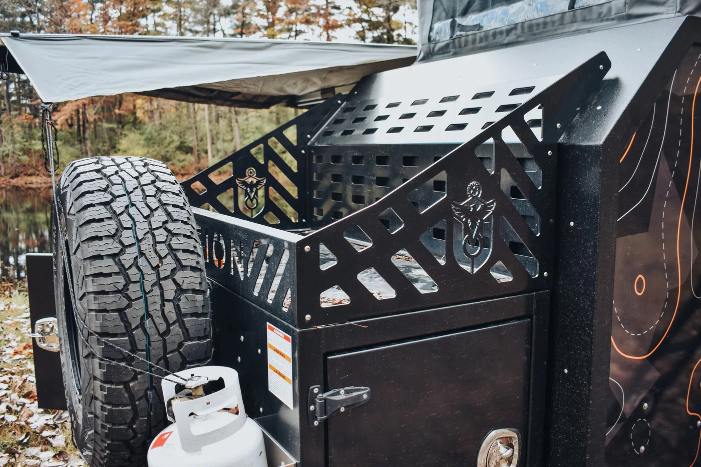 The front of the trailer has room for a spare tire and rim, two propane tanks, and a large storage rack