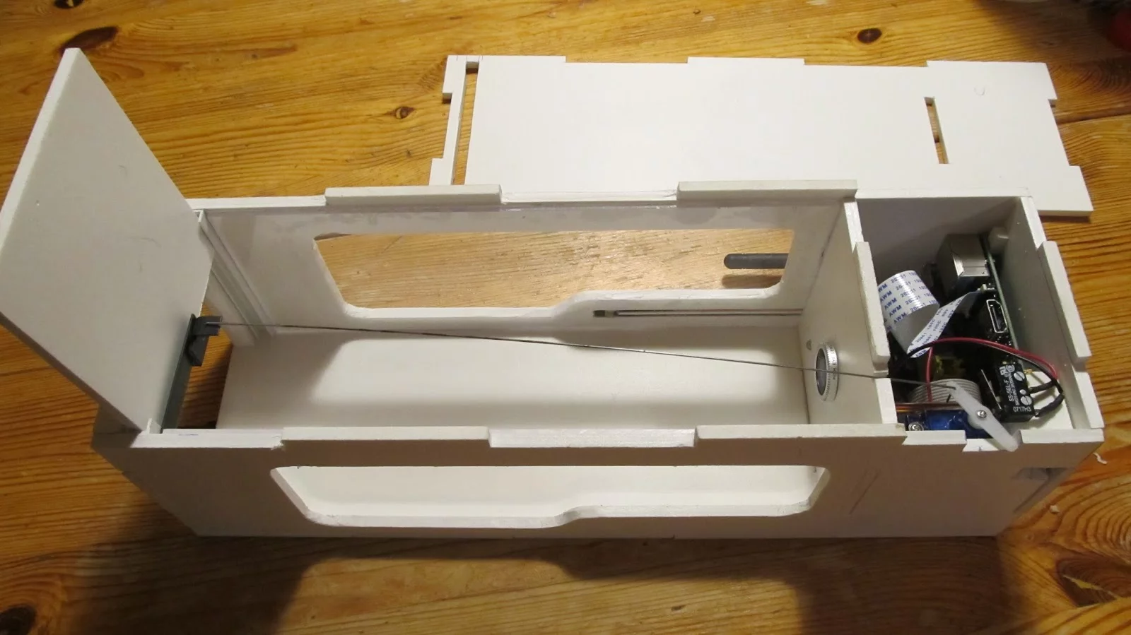 When the IR barrier is triggered, the servo pulls the pin holding the door open and the Pi camera snaps a photo of the new occupant