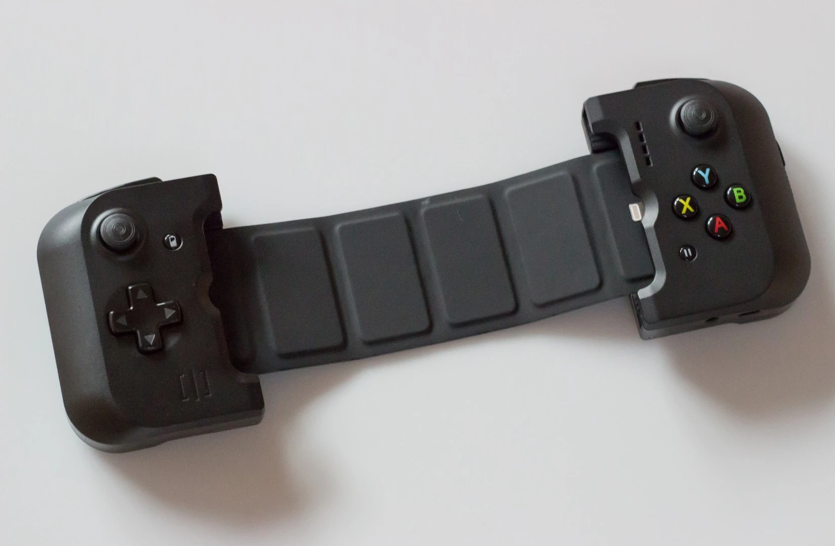 Like the larger version for iPad mini, Gamevice for iPhone has a retractable strap on the back
