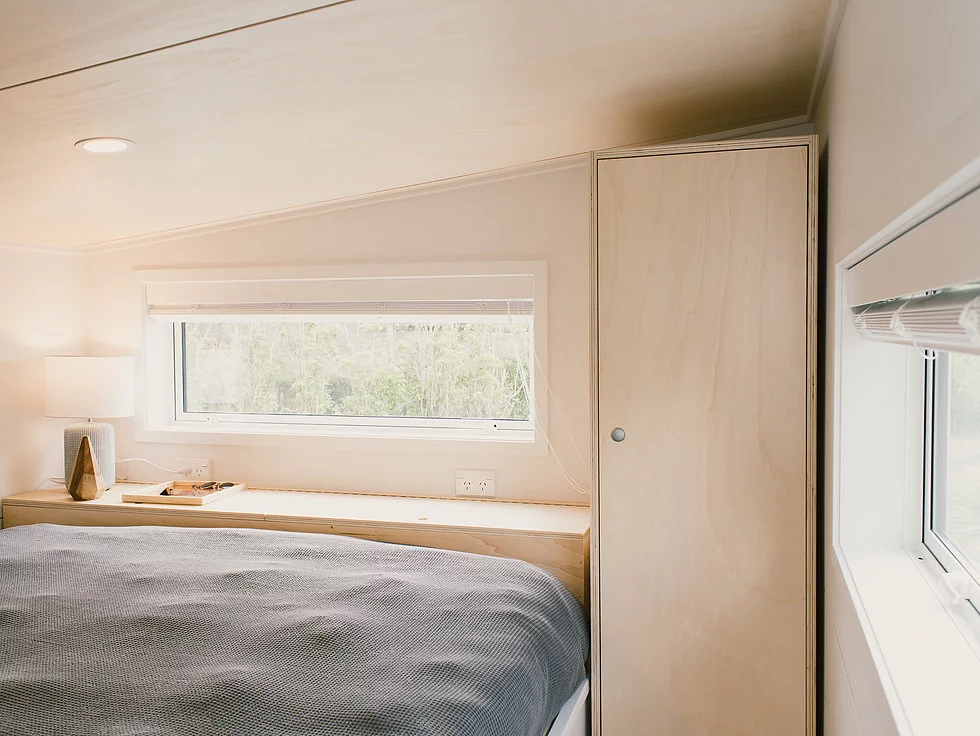 The Archer Tiny House's upstairs loft bedroom includes a wardrobe