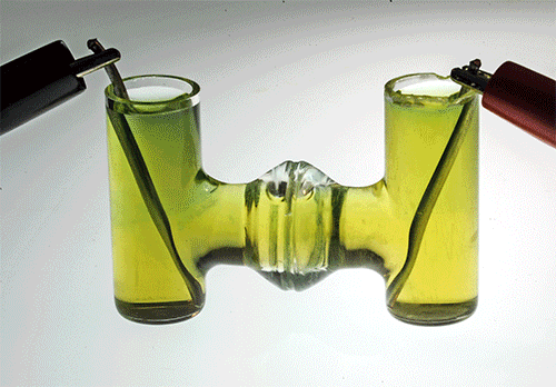 One electrode produces acid (pink) while the other produces a base (purple), in a demonstration of an electrolysis technique similar to that used in a new cement-making process