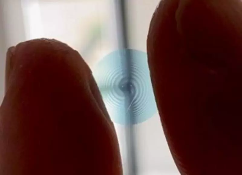 A sample spiral contact lens, held between the fingers of a researcher