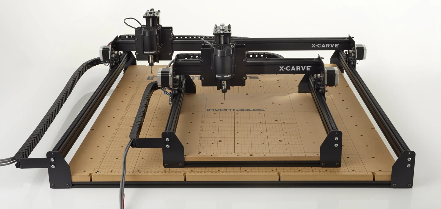 The two members of the X-Carve family, the regular sitting on top of the large model