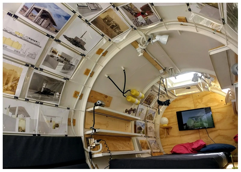 The Bunker includes a wall-mounted TV and wooden shelving, as well as photos mounted on the walls and ceiling