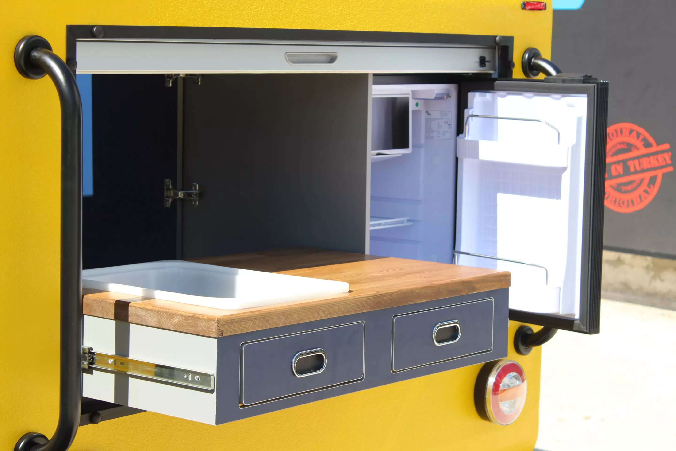 Hotomobil's slide-out kitchen helps to optimize space and keep the Mohican trailer tiny and lightweight