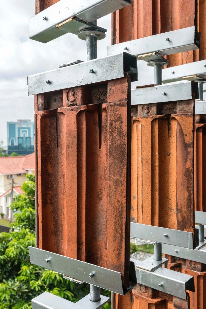Vertical steel rods hold the clay tiles while still allowing free movement to swivel and turn