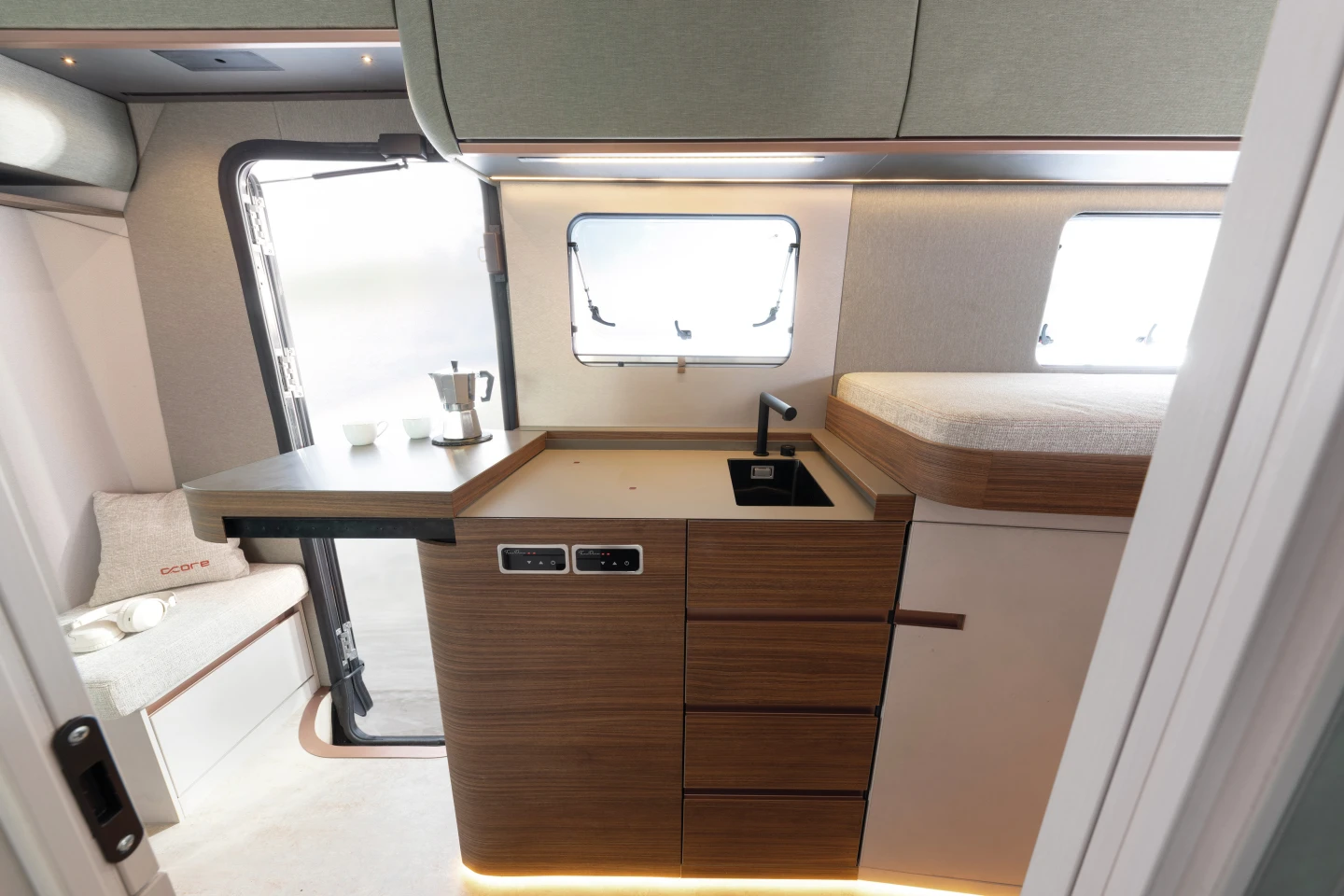 The fully deployed kitchen includes two integrated induction burners, a separate worktop and a rectangular sink