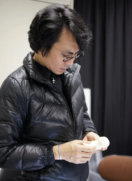 Inventor Hiroshi Ishiguro with the Elfoid P1, a combination mobile phone and mini telepresence robot designed to give a physical presence to callers