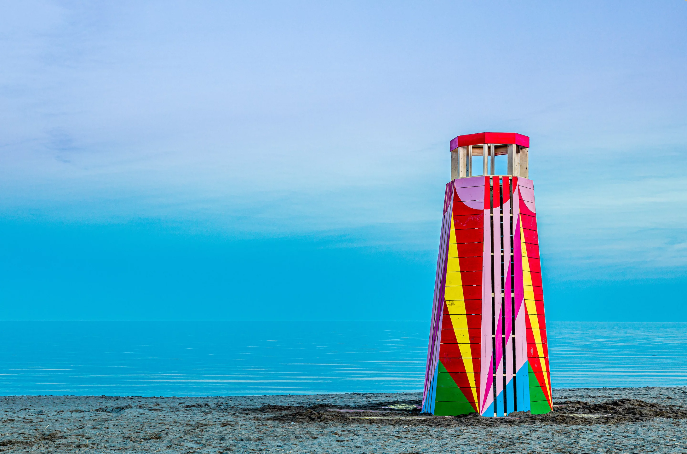 Delighthouse was designed by Nick Green & Greig Pirrie, from the United Kingdom. It's inspired by lighthouses in coastal settings across Canada and elsewhere, and has a colorful exterior that's meant to evoke a lighthearted sense of play