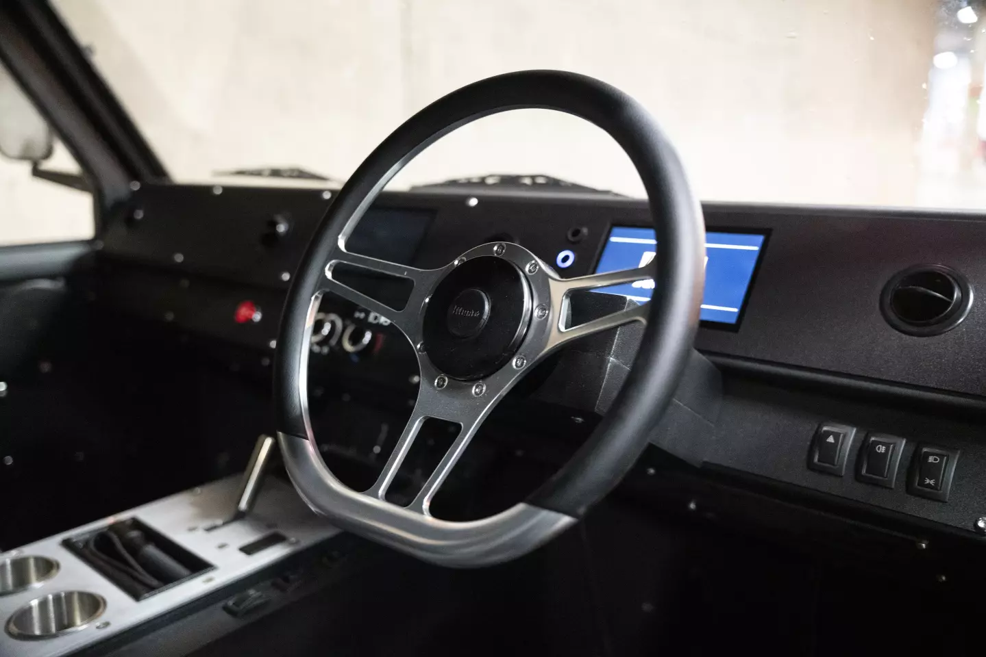 The Munro Mark 1 features a simple interior with waterproof switches, a double DIN screen compatible with Android Auto and Google CarPlay, and a six-speaker audio system