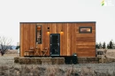 The Tiny Getaway is a compact tiny house that features an "upside-down" layout, situating the living room upstairs and a bedroom downstairs