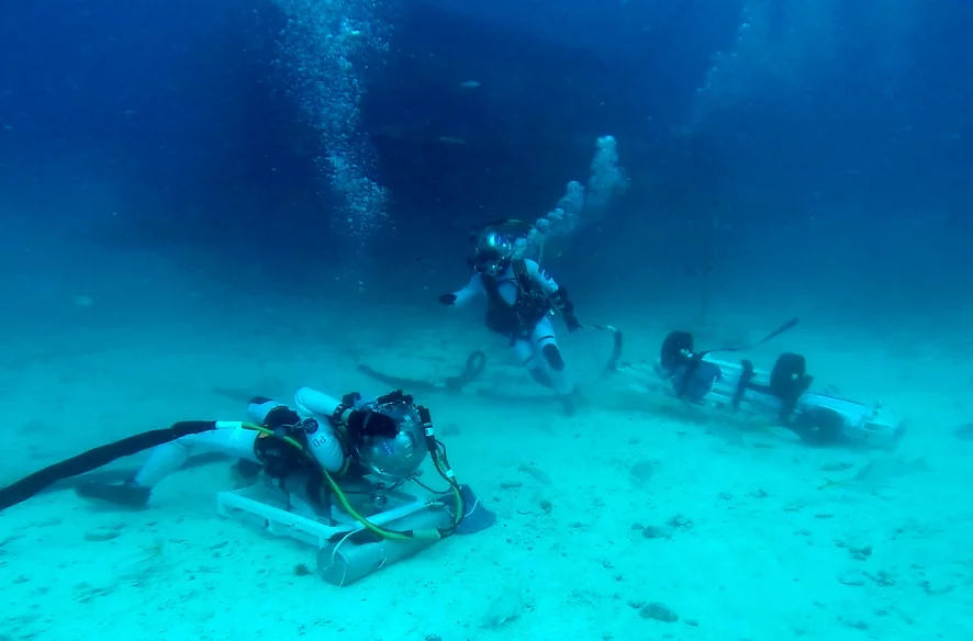 NASA astronaut Kjell Lindgren pulling the Lunar Evacuation System Assembly to come to ESA astronaut Pedro Duque's aid in a simulated lunar rescue
