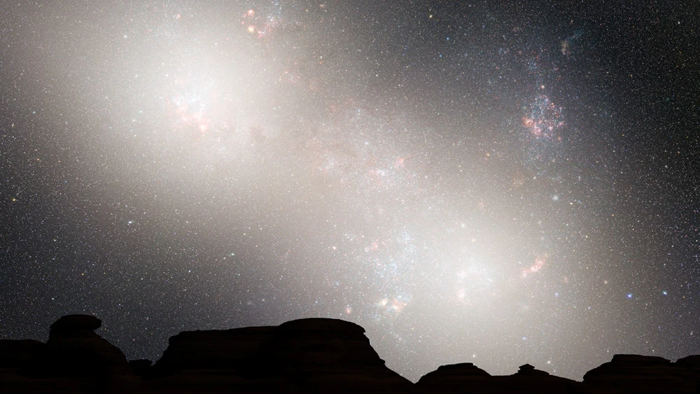 During the second close passage at 5.1 billion years, the cores of the Milky Way and M31 galaxies appear as a pair of bright lobes, while bright nebulae are sparse because interstellar gas and dust were largely depleted by the earlier collision (Image: NASA / STScI)