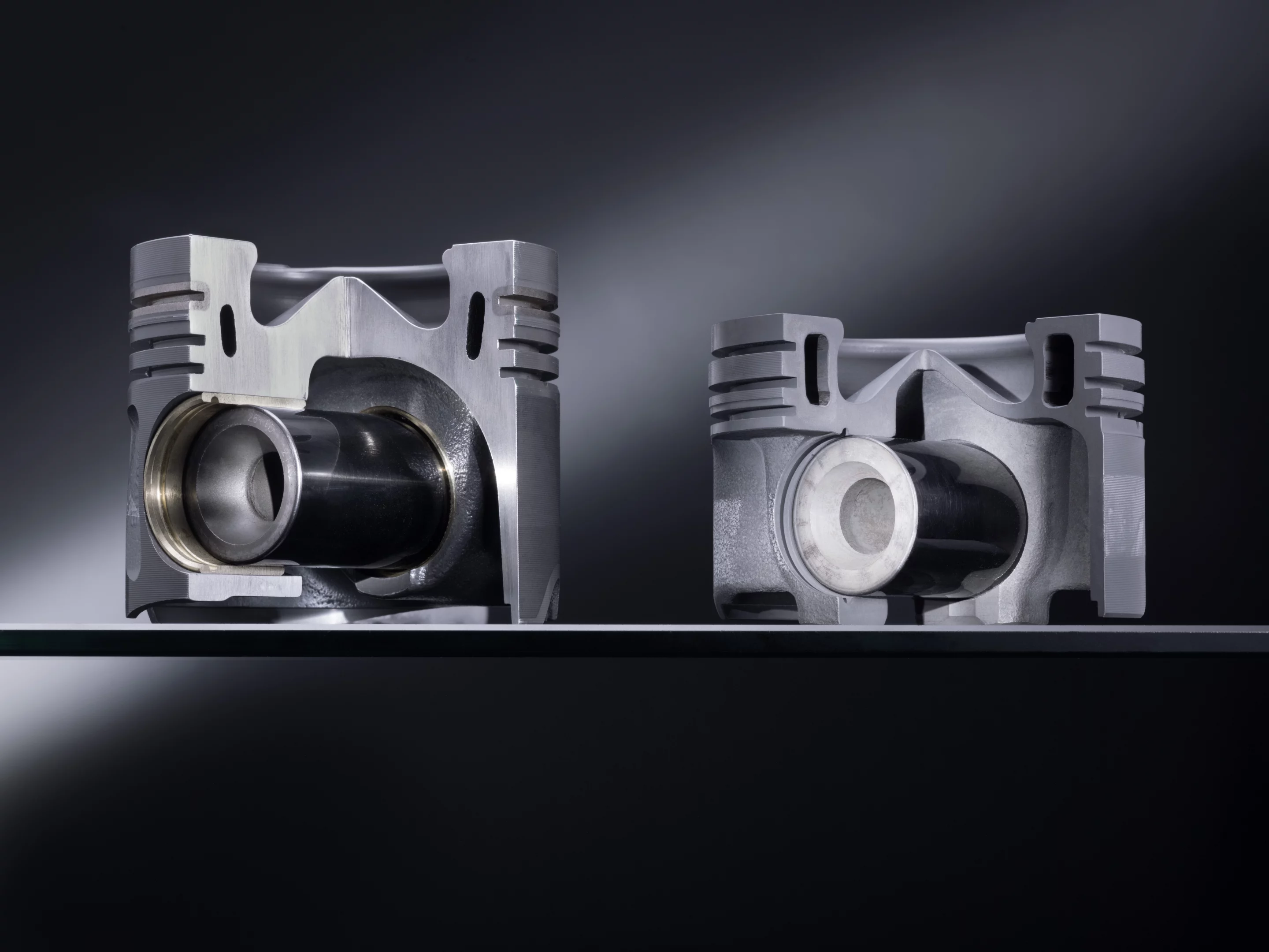 An aluminum piston (left) and one of the new steel pistons (right)