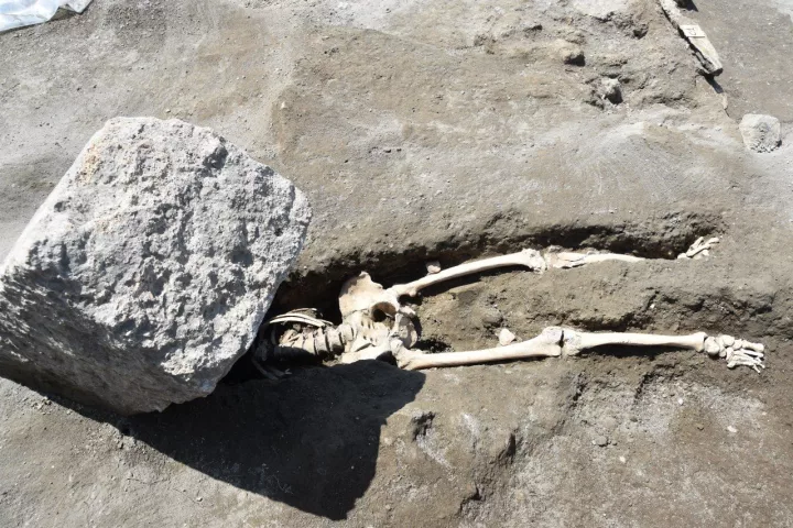 Archaeologists have uncovered the 2,000-year-old skeleton of a man crushed beneath a huge stone block, while trying to flee the volcanic eruption that wiped out Pompeii
