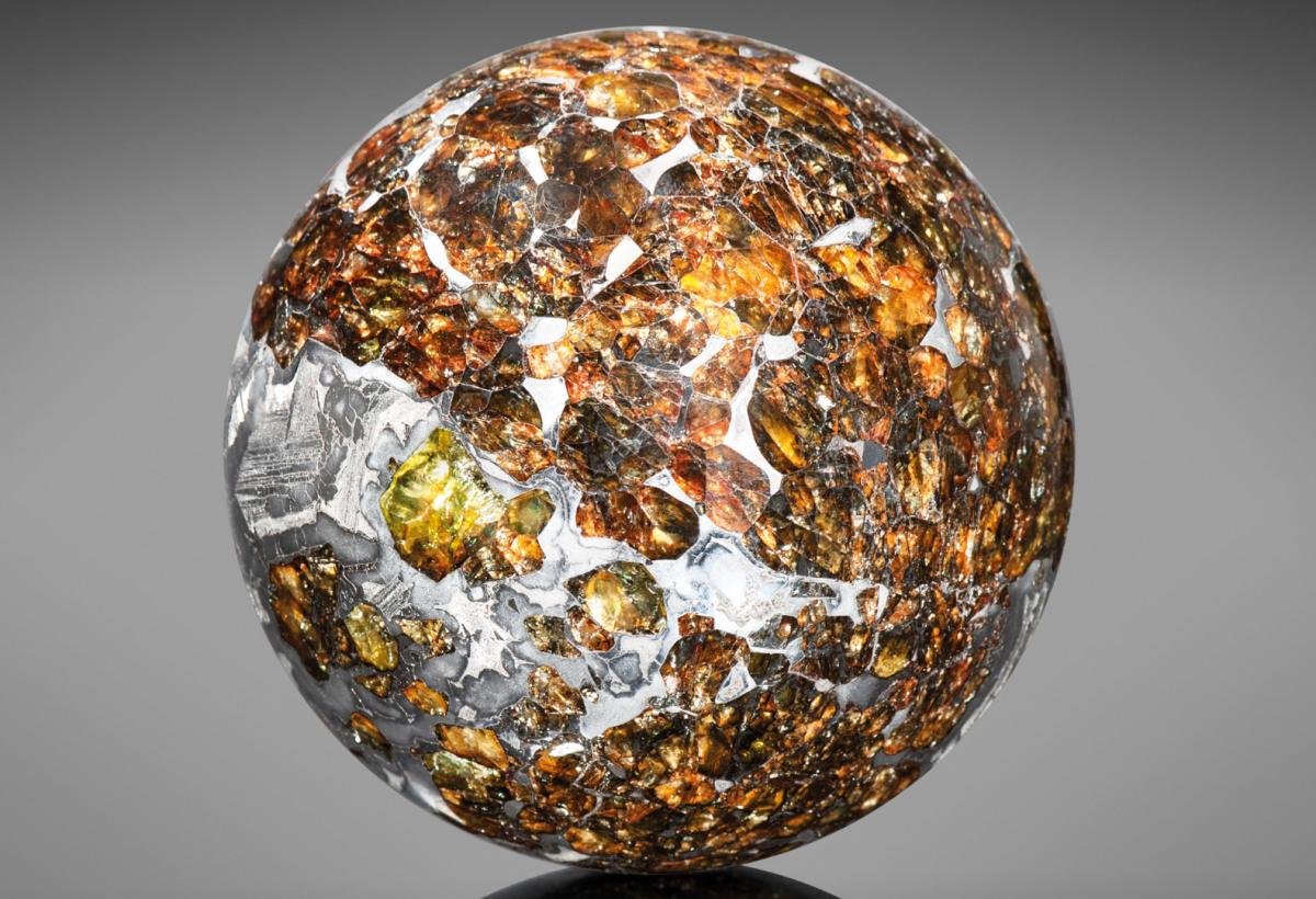 Gemstone from the Gods | Price: $12,696 (£10,000) | Auction Link | This specimen originates from a Seymchan meteorite sample found in Siberia in 1967. The sample has been made into a 2 ½ inch (63mm) sphere weighing 687 grams. Dazzling amber-hued olivine and peridot crystals are suspended throughout the iron-nickel matrix which has been etched to reveal the beautiful metallic crystalline structure.