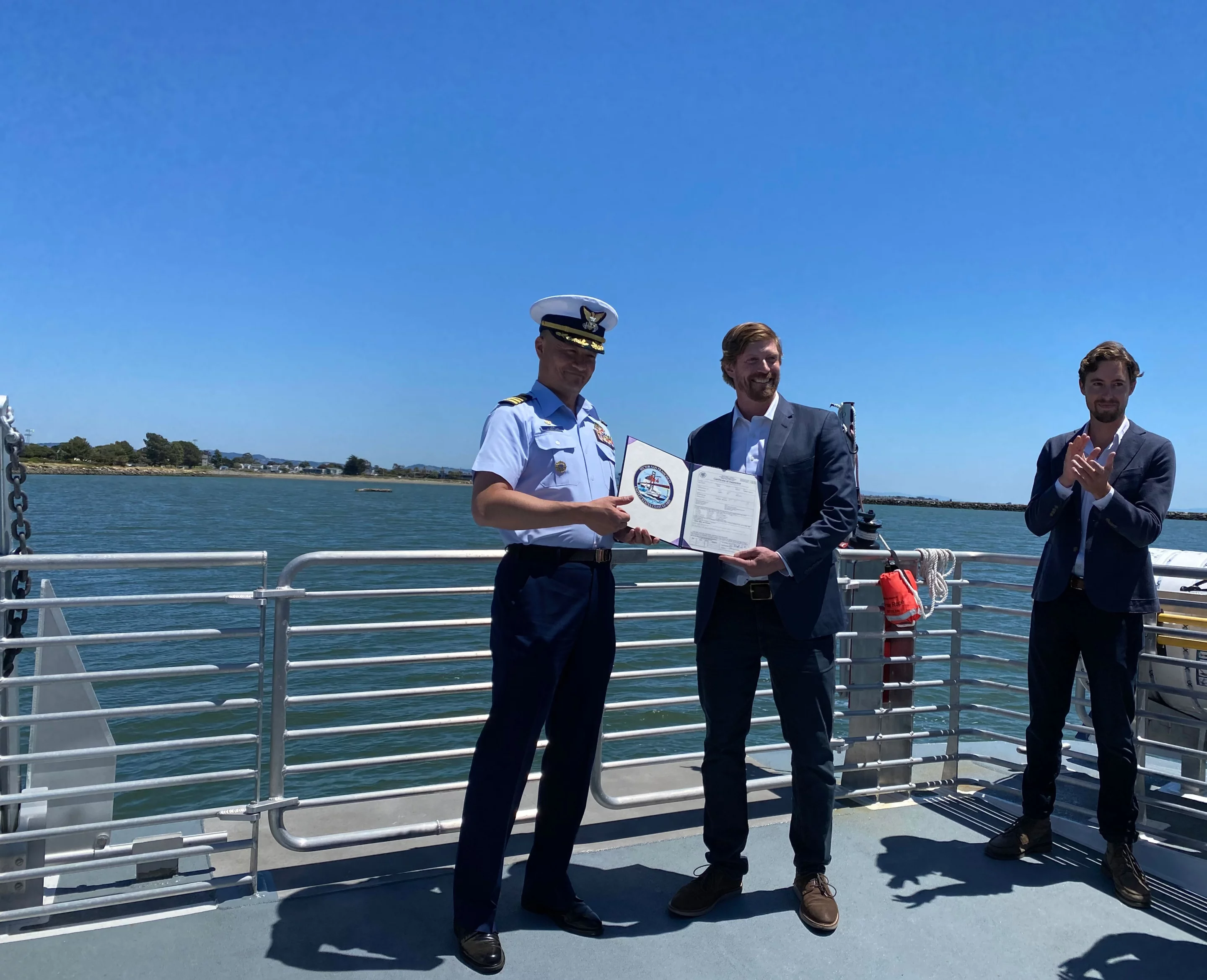 Captain Taylor Q. Lam of the US Coast Guard presents Switch Maritime CEO Pace Ralli with a Certificate of Inspection, which allows the Sea Change to enter commercial operation