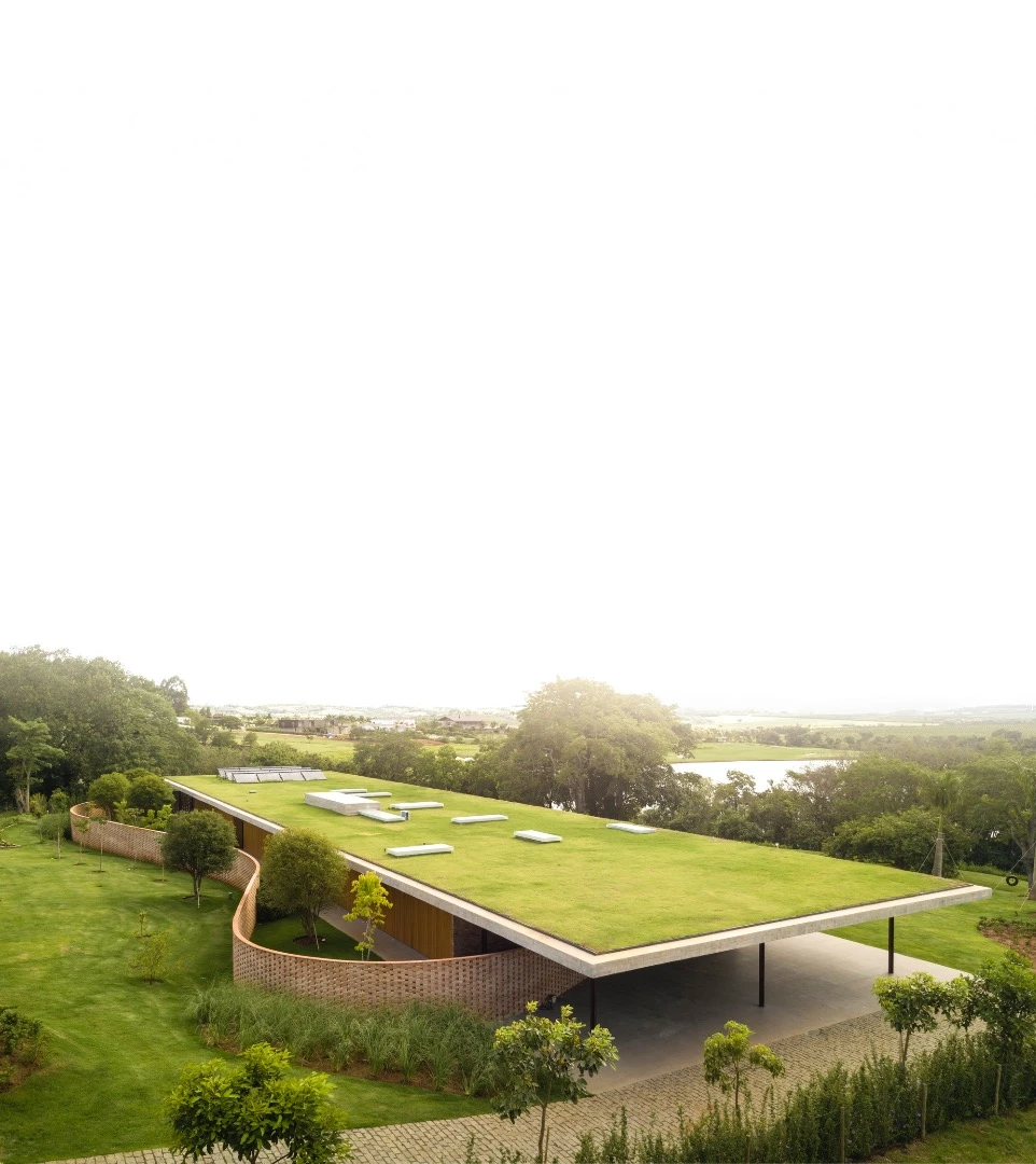 Planar House is topped by a concrete roof that's covered in greenery and designed to blend in with its landscaped garden