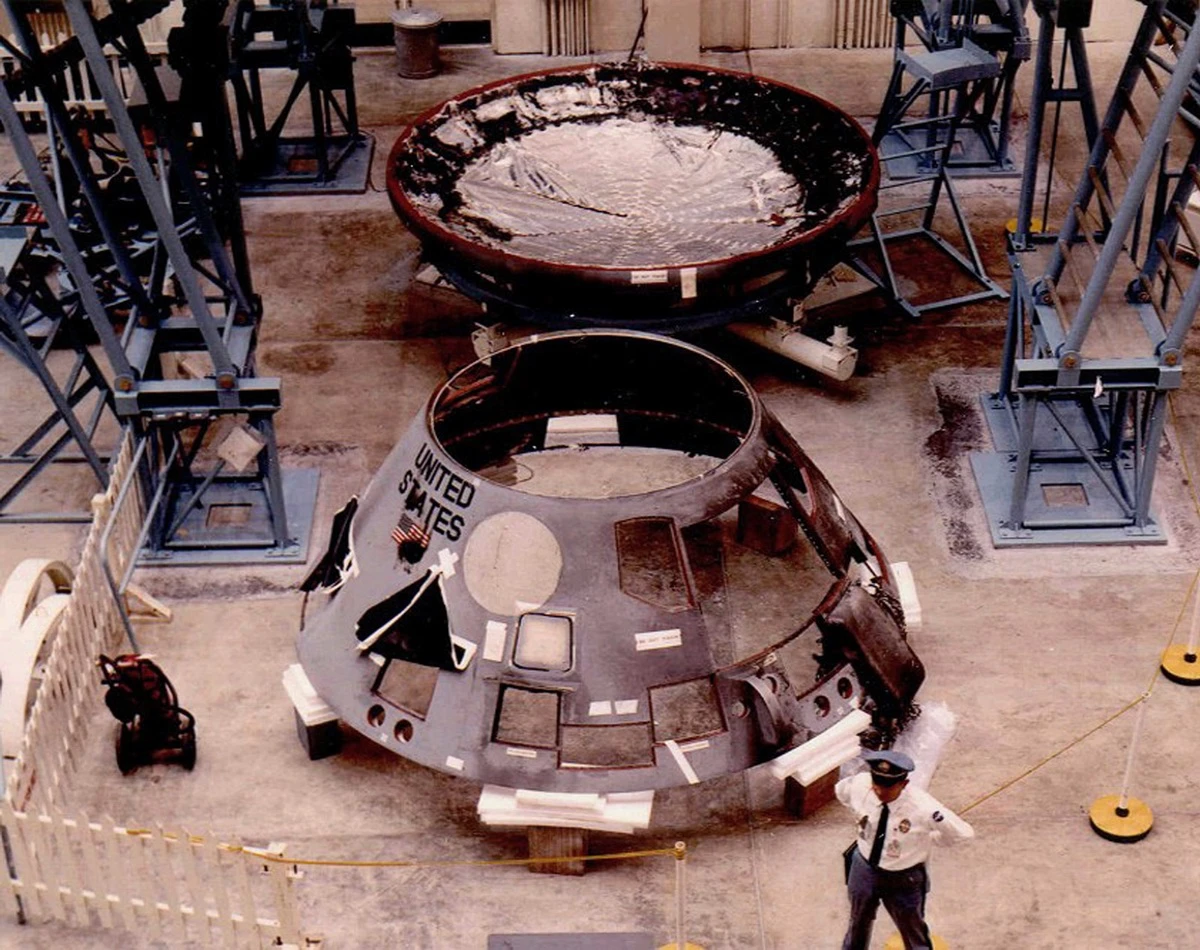 The CM being disassembled while a guard watches
