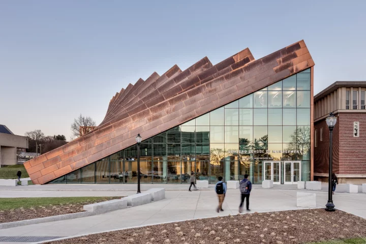 The Business Innovation Hub's exterior features vertical copper pillars, which gradually slope downward, forming a large triangular entrance