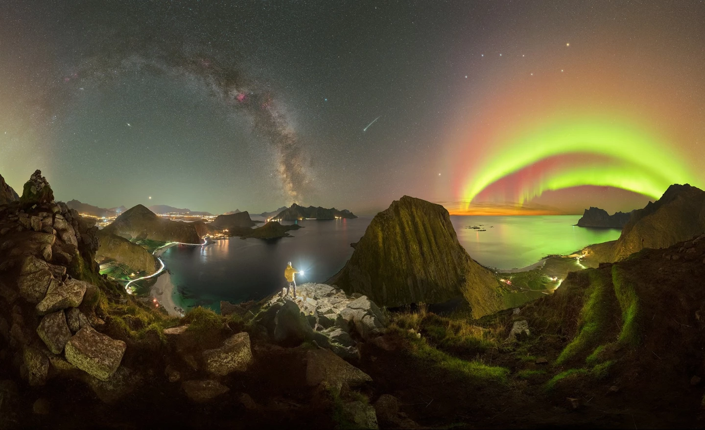 Inception by Giulio Cobianchi, shot in the Lofoten Islands, Norway. The Milky Way galaxy and a pair of auroras arc across the sky, punctuated by a shooting star