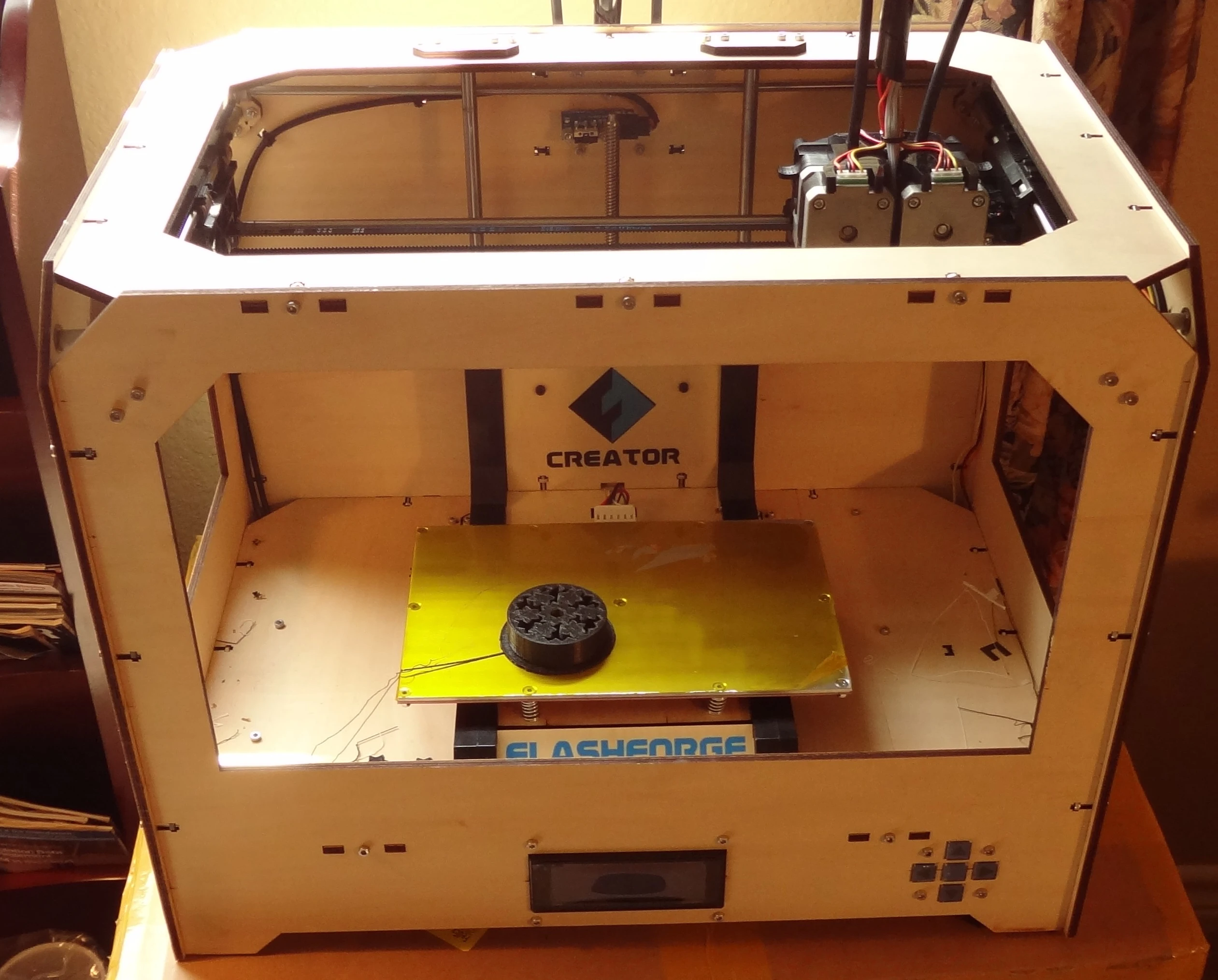 The Flashforge Creator has a wood frame that is open on three sides for easy access. The center gold build platform travels up and down as your item is created layer by layer (Photo: Gizmag)