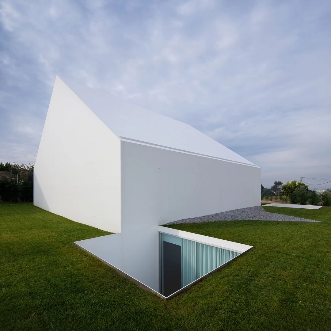 From Aires Mateus Architects this home is simple called ‘House In Leiria’. Almost all of the house is built underground with a doorless, and windowless monolithic impression of a house standing above the ground