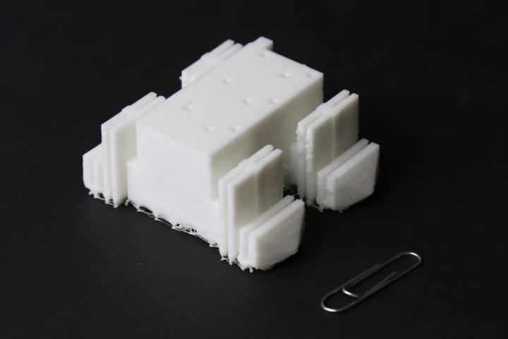 The 67-mm-long (2.6-in) demonstrator robot, with a paper clip for scale