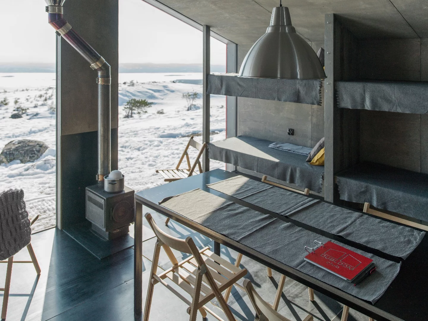 The cabin is warmed with a wood-burning stove