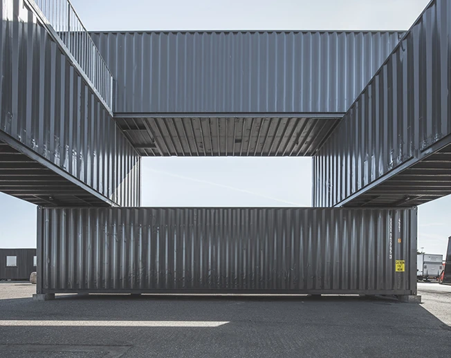 The building comprises three stories of stacked containers
