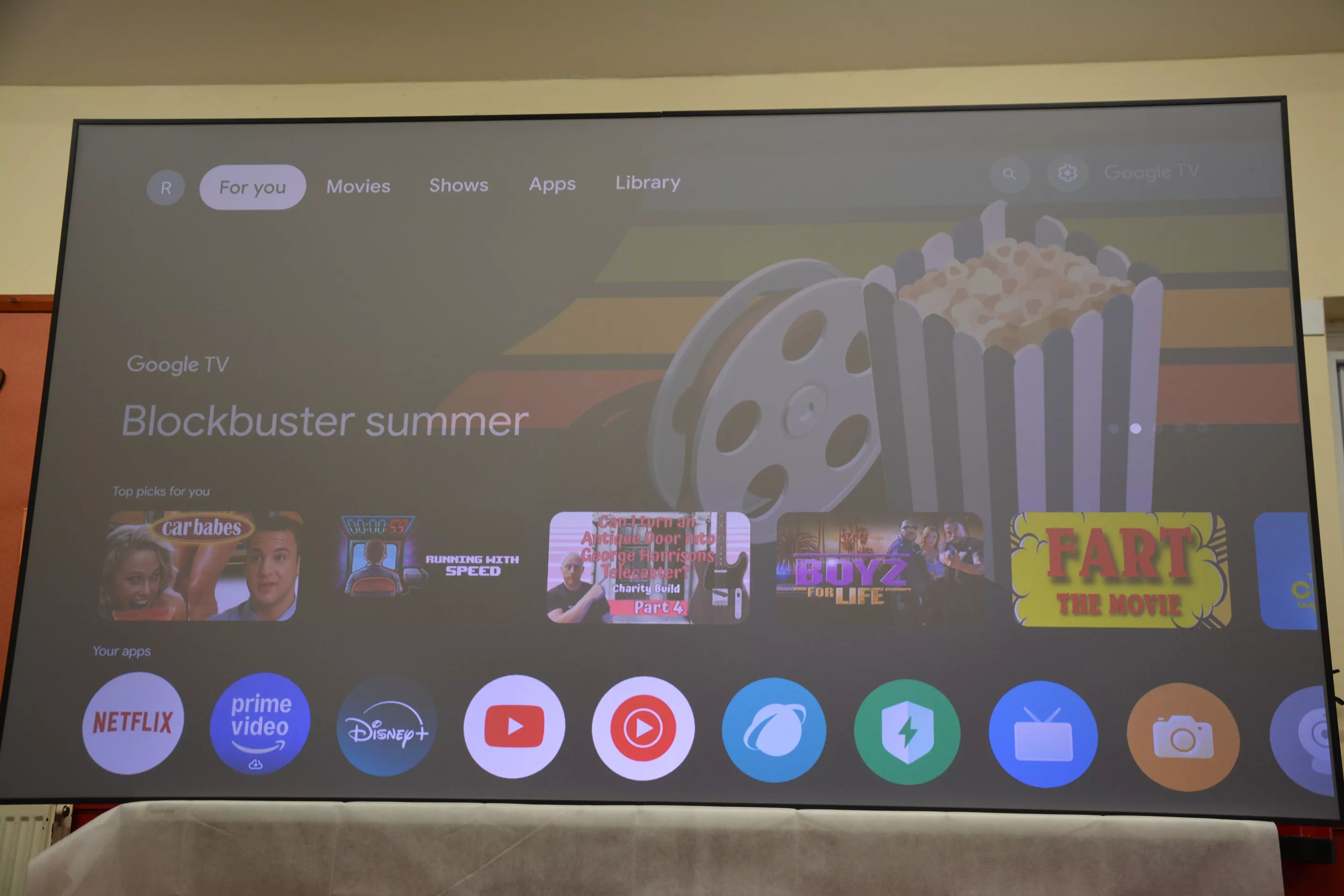 The onscreen visuals popped much more than this photo suggests, with the camera angled slightly to demonstrate the ambient light level (projector throwing 100-inch visuals to a Valerion 100-inch ALR Fresnel long-throw screen, which can be had as an optional extra)