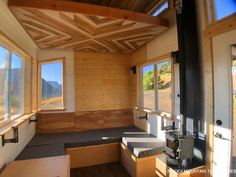 The Timberwolf 24' Tiny House's living room is topped by an elevating bed platform that turns the space into a second bedroom at the push of a button