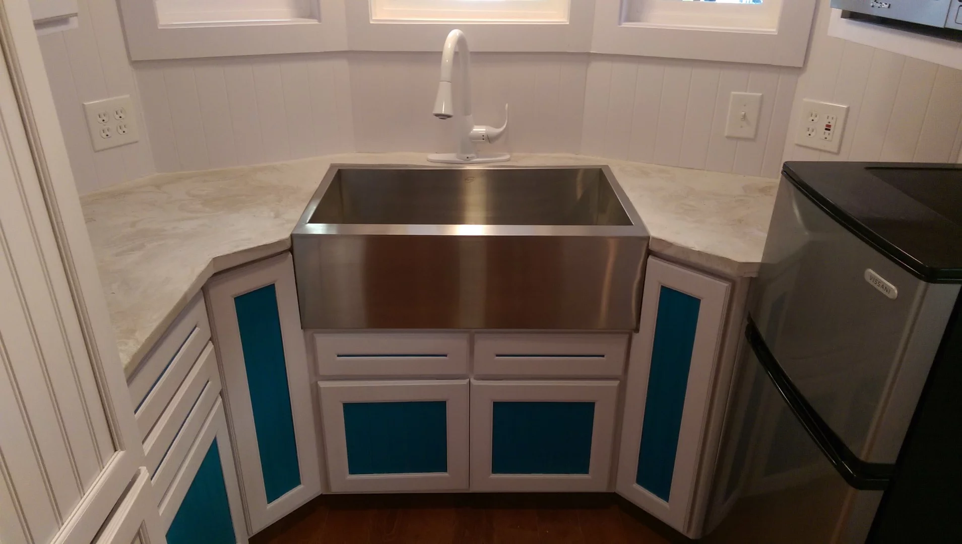 The kitchen includes a steel apron kitchen sink