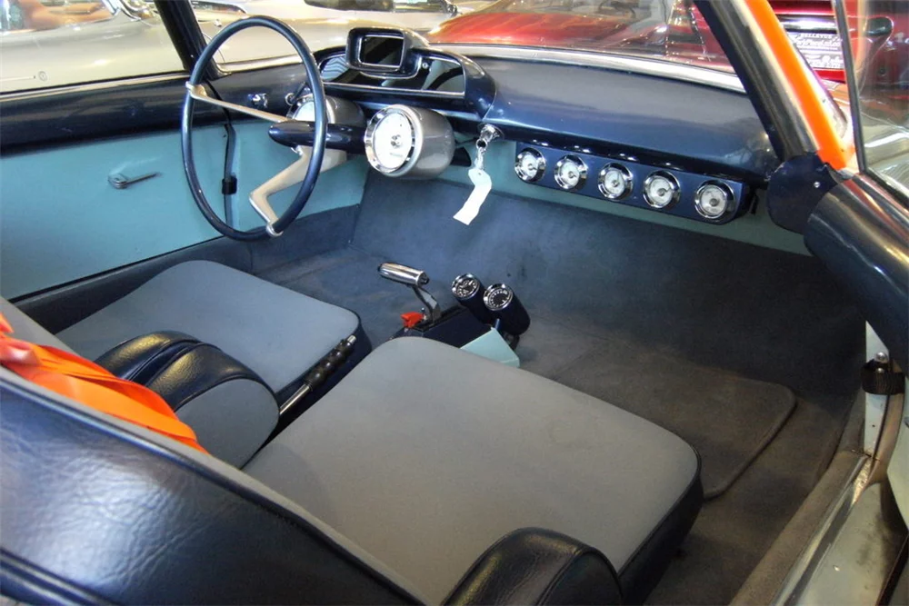 The interior is spartan, with rows of gauges stretching across the dash, two close-set seats, and a bare minimum of controls