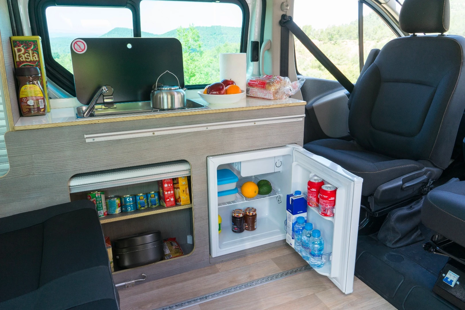 The kitchen block includes a stove, sink and small fridge/freezer