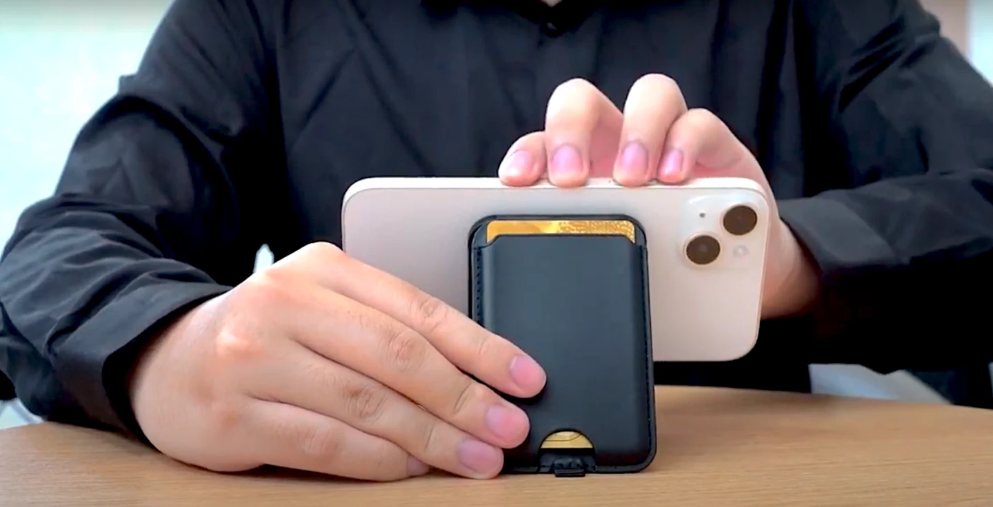 Guy holding wallet to the back of an iPhone